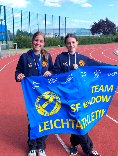 Zwei U16-Athletinnen mit der Team-Fahne bei den Berliner Einzelmeisterschaften 2023